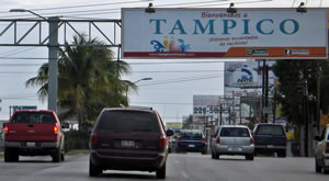 Car driving under Welcome to Tampico sign in Mexico