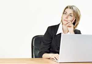 Woman at laptop computer considering Home insurance