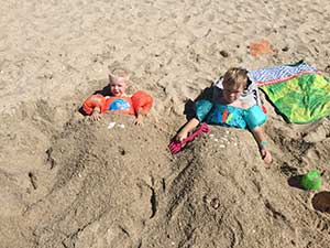 Children buried in the sand on Mexico beach