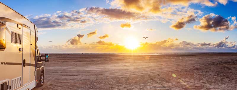 RV parked on the sand on Rocky Point beach at sunset