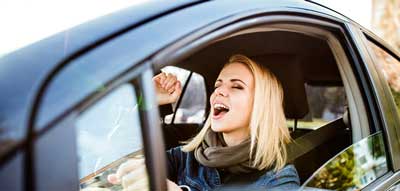 Woman singing Christmas songs in her car